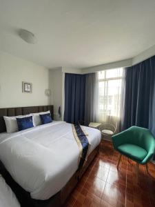 曼谷Acozyposhtel的一间卧室配有一张大床和一张绿色椅子