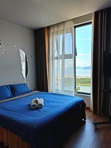 下龙湾Ha Long Bay View Studio的一间卧室设有一张蓝色的床和大窗户