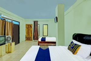 普兰巴南SPOT ON 91540 Ukuh Guesthouse的一间卧室配有一张床和一台电视。