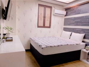 首尔明洞京东酒店的一间小卧室,卧室内配有一张床铺