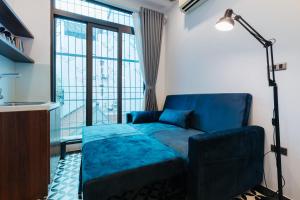 河内Hanoi Old Quarter的客厅设有蓝色的沙发和窗户。