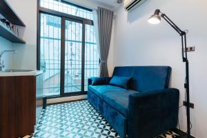 河内Hanoi Old Quarter的客厅设有蓝色的沙发和大窗户