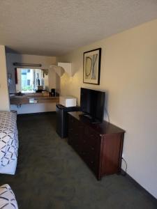 阿灵顿Smokey Point Motor Inn的配有一张床和一台平面电视的酒店客房