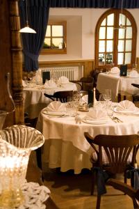 拉维拉Hotel La Villa的用餐室配有带白色桌子设置的桌子