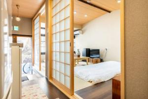 京都Minami Toji---JP Style Guesthouse in Kyoto的卧室配有一张床铺,位于带滑动玻璃门的房间