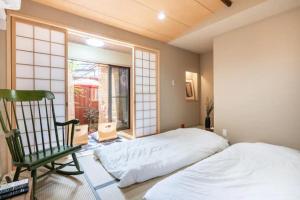 京都Minami Toji---JP Style Guesthouse in Kyoto的卧室配有床、椅子和窗户。