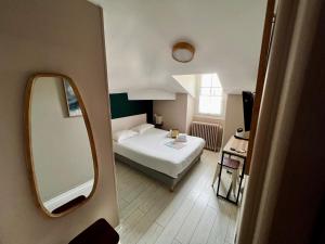 比亚里茨圣詹姆斯酒店的一间小卧室,配有一张床和镜子