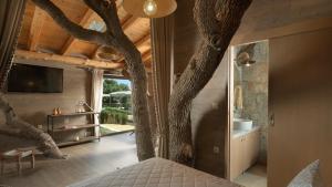 阿迪斯普普伦Stolidi Mou Treehouse的卧室,天花板上长着一棵树