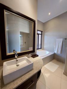莫科帕内Sofala Lodge的浴室配有盥洗盆和浴缸。