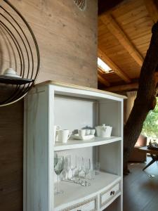 阿迪斯普普伦Stolidi Mou Treehouse的白色的架子,带玻璃杯和酒杯