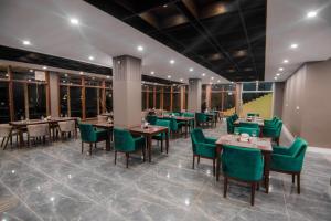 锡卡都Tibet Hotel的用餐室配有桌子和绿色椅子