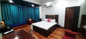 古瓦哈提The PALM SUITES , Incredible India Tourism的一间卧室配有一张床、一把椅子和一张桌子