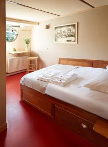 瓦兹河畔欧韦Péniche Daphné's的一间卧室配有一张木架大床