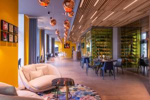圣马洛圣马洛格兰德金色郁金香酒店的餐厅拥有黄色的墙壁和桌椅