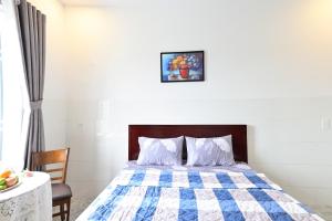Hoi NghiaRuby Hotel - Tân Uyên - Bình Dương的一间卧室配有一张带蓝色和白色被子的床