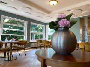吕特延堡达斯奥斯特斯布里克酒店的一张大花瓶,桌子上放着粉红色的花