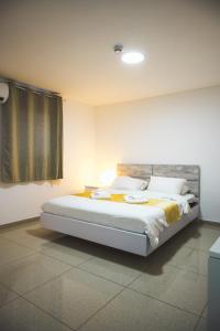 亚实基伦Agamim Hotel Ashkelon的一间卧室,卧室内配有一张大床