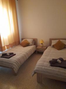 马萨尔福恩Gozo Marsalforn的一间卧室设有两张床、一盏灯和一扇窗户。