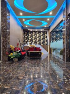 武吉丁宜Dnaiko Syariah Hotel的大堂配有沙发和蓝色天花板