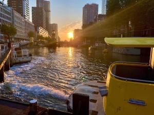 鹿特丹Houseboat holiday apartments Rotterdam的日落时分在城市的河流中乘船
