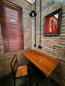 里辛RUMAH @ Sawah Ijen的砖墙间里的一张木桌和椅子