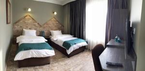 乔尔卢Grand Park Hotel Corlu的酒店客房设有两张床和电视。