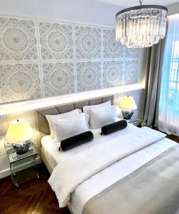 华沙MONDRIAN Luxury Suites & Apartments Market Square I的一间卧室配有一张带两盏灯的大型白色床。