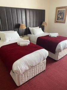凯西克George Hotel的红色和白色的酒店客房内的两张床