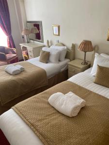凯西克George Hotel的酒店客房,配有两张带毛巾的床