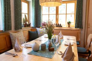 巴德伊舍Gasthof Rettenbachalm的餐桌上摆放着玻璃杯和鲜花