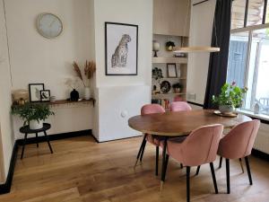 格罗宁根Characteristic ground floor apartment with box bed的一间带桌子和粉红色椅子的用餐室