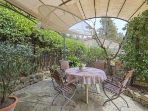 潘札诺Holiday Home Vignole by Interhome的庭院里配有桌椅和遮阳伞