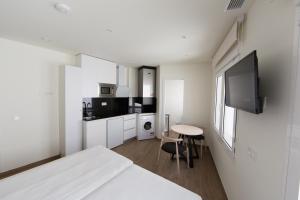 马德里Apartamentos Centro Jardines的白色的客房配有床和小桌子