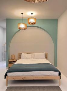 华欣Warm White Hua Hin House的一间卧室配有一张大床和两个吊灯