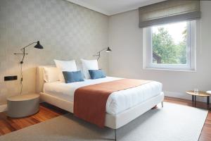 宏达瑞比亚Villa Jaizubia Golf by FeelFree Rentals的一间卧室配有一张带蓝色枕头的床和一扇窗户。