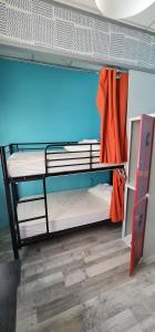 马德里GREEN Hostel MADRID GRAN VIA的客房设有两张双层床和橙色毛巾
