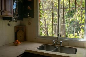 卡塔马卡Casa de campo La Brea的厨房水槽,带窗户和一碗水果
