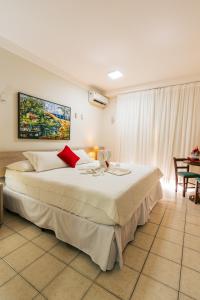 因巴塞科斯塔多斯克奎伊洛斯度假酒店的卧室配有带红色枕头的大型白色床
