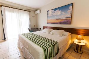 因巴塞科斯塔多斯克奎伊洛斯度假酒店的一间卧室设有一张床和一个大窗户