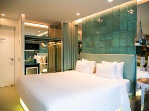 里斯本WC精品酒店的卧室配有白色的床和绿色的墙壁