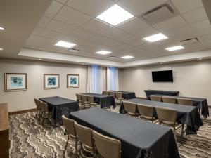 苏城Staybridge Suites - Sioux City Southeast, an IHG Hotel的客房设有桌椅和平面电视。