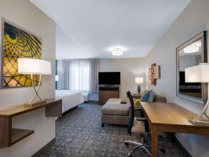 苏城Staybridge Suites - Sioux City Southeast, an IHG Hotel的配有一张床和一张书桌的酒店客房