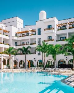 普拉亚布兰卡杨扎公主套房度假酒店的大楼前设有游泳池的酒店