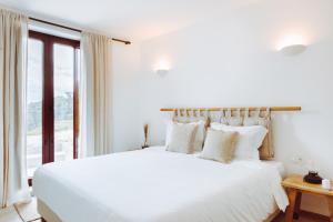 阿马兰特Oliveiras Village — Agroturismo的白色的卧室设有一张大床和一个窗户