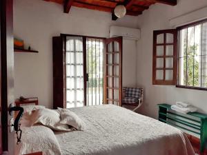 耶尔瓦布埃纳Casa de las Palmeras的一间卧室配有一张带白色床单和窗户的床。