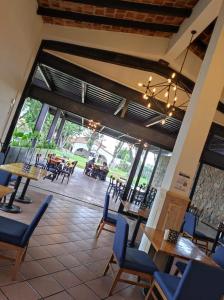 圣路易斯波托西Hotel Sand´s San Luis的餐厅设有桌椅和大窗户。