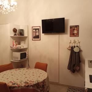 热那亚La Corte di Paola 1 e 2的一间房间,墙上有桌子和电视