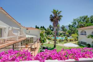 滨海阿热莱斯小屋酒店的从带紫色鲜花的别墅阳台欣赏风景