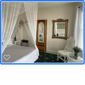 五月岬郡麦康伯酒店 的卧室配有白色的床和椅子
