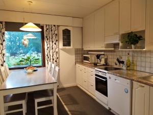 霍萨Holiday House Mäntyniemi的厨房配有白色橱柜和台面